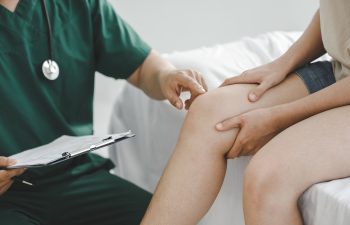 patient is consulting a therapist and explaining with injured leg or knee after the accident and explain to her the diagnosis of the problem in clinic, Sport exercise injuries.